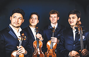 Four members of the Schumann Quartet against a black background